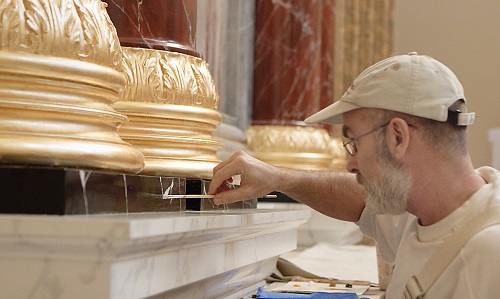 A tradesman sculpting a new plaster cornice