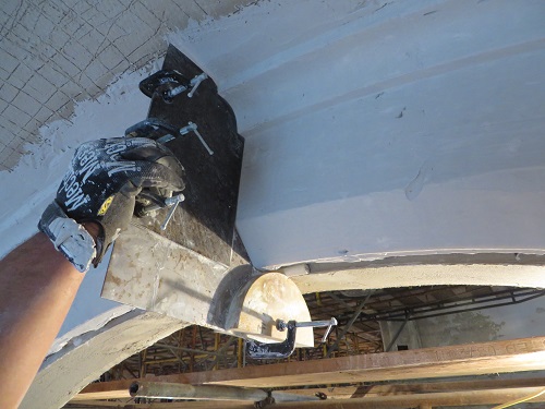 A tradesman sculpting a new plaster cornice